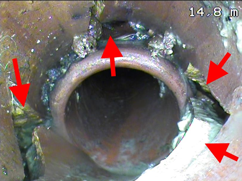 Image d'inspection montrant une conduite d'égout cassée à 14,8 m, le défaut désigné par des flèches.